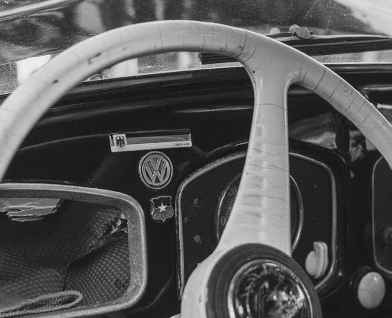 Une photo en noir et blanc d'un volant et d'un tableau de bord